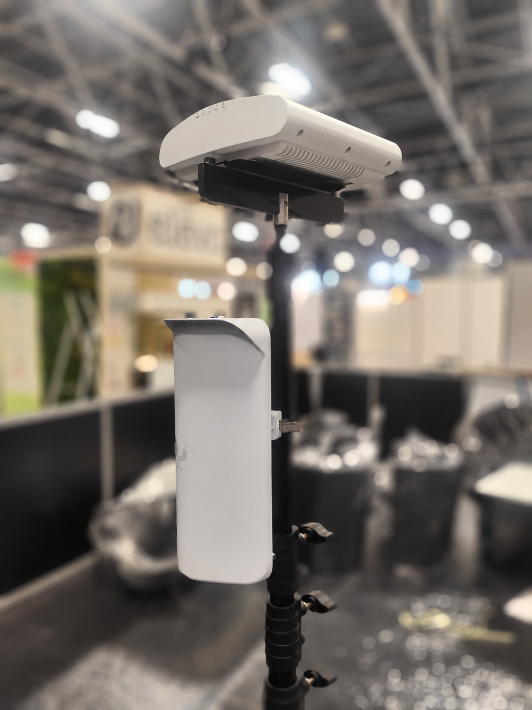 Mast in an exhibition hall carrying a WiFi access point above a 60GHz point-to-point backhaul link