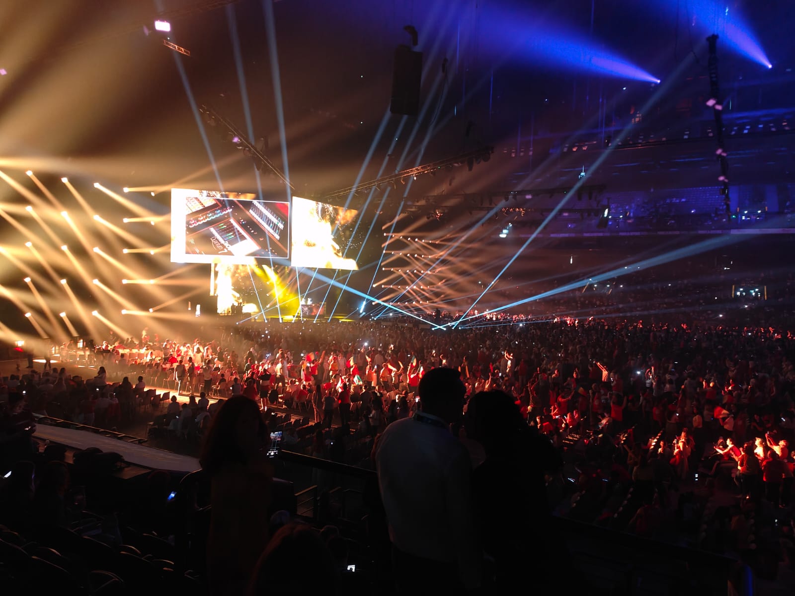 Audience beneath golden stage lighting