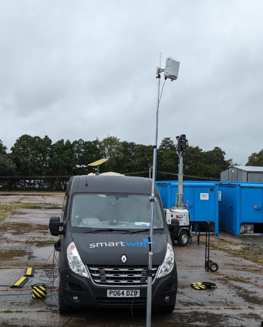 Connectivity van with a raised mast at a construction site