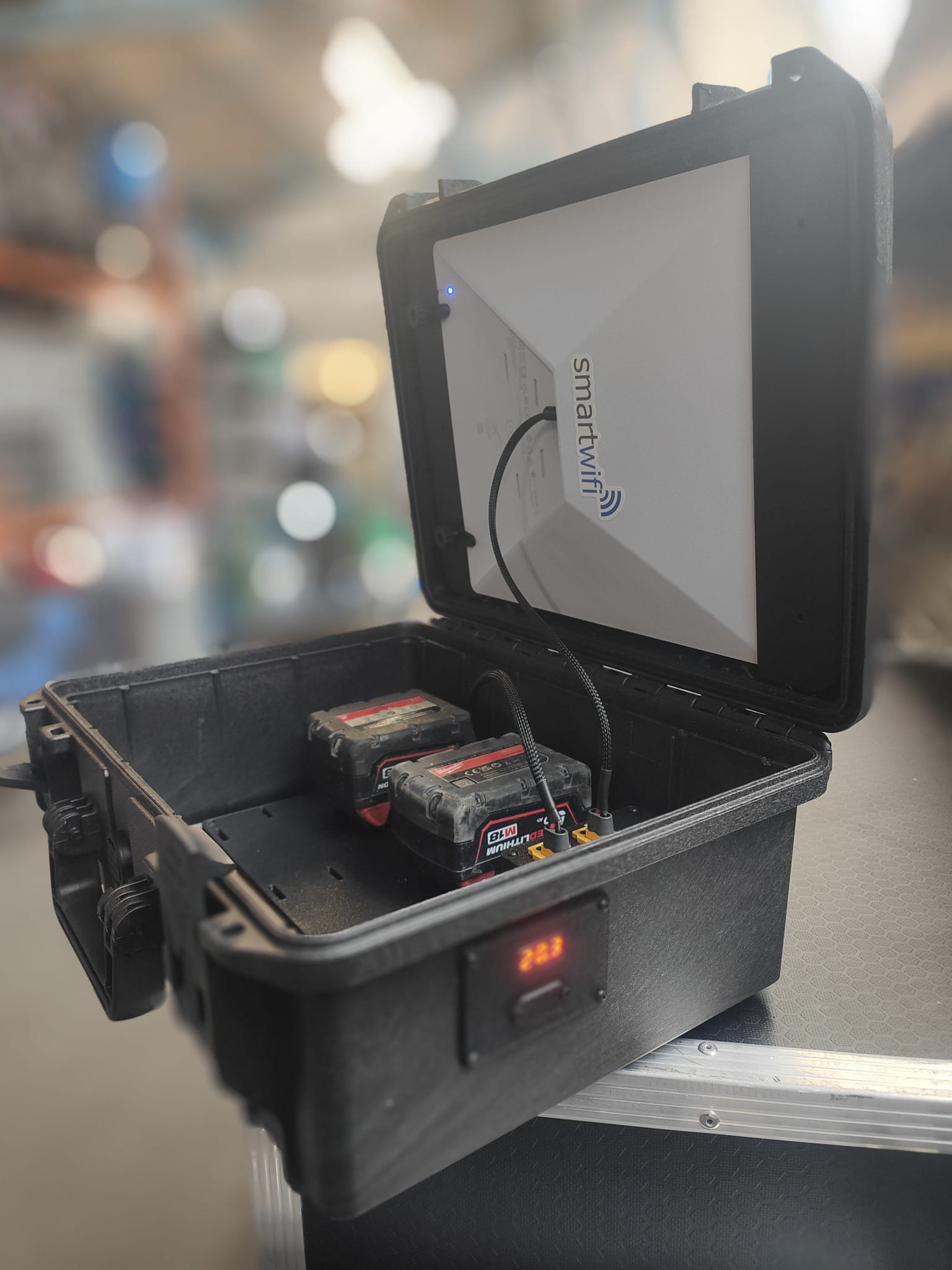 SmartWifi Starlink Mini kit in a rugged case, with the dish mounted in the lid and two Milwaukee M18 batteries